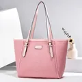 Detail van een roze geweven shopper met lederen handvatten en gouden metalen hardware - Roze