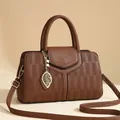 Sac Boston gaufré caramel avec pendentif feuille et texture en cuir souple pour femme - Marron