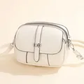 Chic cream mini round crossbody bag with silver bow lock and dual zipper detail - Off White