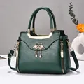 Elegant dark green textured leather handbag with gold flamingo heart motif and pearl charm - Green