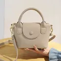 Sac bandoulière chic en cuir beige grainé avec poignée et finitions dorées - Abricot