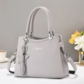 Detail of lychee pattern leather tote bag with silver hardware and star charm accessory - Light Gray