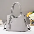 Macro shot of gray textured leather handbag with gold metal hardware and star pendant - Gray