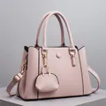 Detailed macro of pink litchi grain leather handbag with mini coin purse and gold hardware - Pink