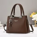 Détail de la texture cuir grainé et des finitions métalliques argentées sur un sac marron - café