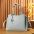 Trapezoidal grey-blue lychee pattern leather handbag with silver hardware and crossbody strap - Blue