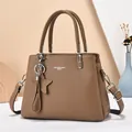 Detailed macro of brown litchi pattern leather tote with star pendant and silver hardware - Khaki