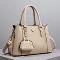 Chic beige lychee leather tote bag with mini accessory and golden hardware at 45-degree angle - Khaki