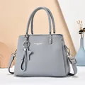 Detail of grey lychee leather tote bag with silver hardware and star charm pendant - Blue