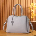 Fashionable lavender leather handbag for women with textured finish and elegant metal charm - Purple