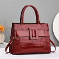 Red crocodile embossed patent leather handbag with wide buckle and cross-body strap - Medium / Red