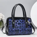 Blaue Leopard-Kissentasche mit schwarzem Lackleder und goldenen Metalldetails für Damen - Blau