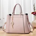 Pink lychee texture tote bag with star pearl charm and golden kangaroo logo on the desk - Pink