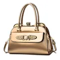 Glossy gold patent leather handbag with diamond frame buckle and vintage metal crest emblem - Champagne Gold
