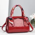 Détail du sac oreiller rouge effet croco avec poignée en foulard et ferrures dorées - Rouge