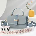 Light blue textured crossbody bag with wide floral shoulder strap and H-shaped gold clasp - Sky Blue