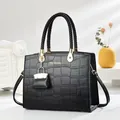 Elegante schwarze Krokodilmuster-Handtasche mit gewebten Griffen und Logo-Aufdruck - Schwarz