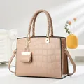 Elegante beige Handtasche mit Krokodil-Prägung und dekorativem Mini-Taschenanhänger - Khaki