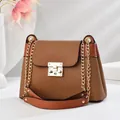 Détail de sac à main marron tissé avec fermoir doré rotatif et bandoulière en chaîne - L26 L10 H21 / Jaune Terre