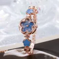 Makroansicht der roségoldenen Blumenuhr mit Kristalllünette und blauem Marmorzifferblatt - Blau