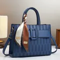 Dettaglio della borsa blu scuro goffrata con manico in seta e fibbia decorativa - 30cmx10cmx23cm / Blu