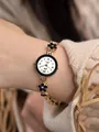 Nahaufnahme der Roségold-Quarzuhr mit schwarzem Blumenarmband am Handgelenk - Roségold Schwarze Blume