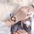 Damen-Armbanduhr in Roségold mit Stern-Mond-Armband in einem gemütlichen Lifestyle-Szenario - Rosa