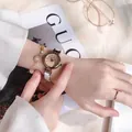Detail shot of elegant women's watch set with pearl bracelet and starry charm accents - White