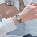 Close-up van een vintage vierkant horloge met groene leren band om de pols - Groen