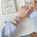 Pink leather watch with rose gold hexagonal case and daisy bracelet on white desk - Pink