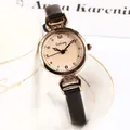 Reloj vintage mujer oro rosa con esfera crema y correa de cuero negro en una taza - Negro