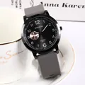 Minimalist men's quartz watch with grey silicone strap and black dial on white background - Gray