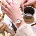Elegant ladies quartz watch with beige leather strap and rose gold case on a wrist - White