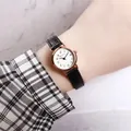 Detailed close-up of a women quartz watch with white dial, date window, and black leather strap - Black
