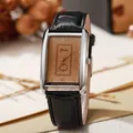 Detalle del reloj rectangular plateado con esfera champán y correa de cuero negro con relieve - Grande / Negro