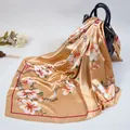 90cm silk-like scarf with gold plum blossom print draped over a black luxury handbag - Khaki
