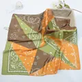 Macro detail of bohemian paisley pattern and silk satin texture on a green square scarf - 53cm / Orange