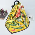 Foulard quadrato in seta gialla con stampe floreali abbinato a una borsa nera - Giallo