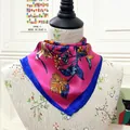 Close-up of a square silk scarf with floral bird print and navy contrast borders - 60CM / Rose Red