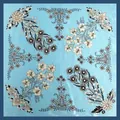 Detalle de un elegante pañuelo de seda cuadrado con estampado de lirios en base azul claro - Cuadrado / Azul cielo