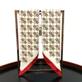 Detail van handgerolde randen van een zijden sjaal met geometrische patronen op metalen rek - Rood