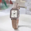 Dettaglio di un orologio quadrato vintage con cinturino in pelle marrone e quadrante beige - Cachi