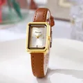 Primer plano de reloj vintage cuadrado dorado con números romanos y correa de cuero marrón - Caja Dorada Correa Marrón Esfera Blanca