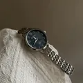 Detail of silver steel link strap and navy dial watch resting on white knit fabric - Dark Blue