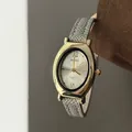 Macro shot of an elegant oval gold watch with a champagne dial and grey leather strap - Gray