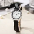 Detail of vintage silver tonneau-shaped watch with white dial and black leather strap - Black Strap Silver Case White Dial