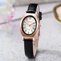 Macro detail of oval rose gold watch case with Roman numerals and black leather strap - Black Strap Rose Gold Case White Dial