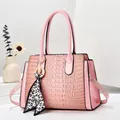 Detailed view of pink croc-embossed handbag with elegant leopard print scarf on handle - Pink