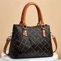 Ensemble sac seau classique avec motif lettres et anses marron sur support blanc - Sac à Main et Pochette / Jaune Terre et Noir