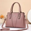 Detail of elegant mauve lychee grain handbag featuring gold buckle and V-shaped stitching - Length 32 Width 13 Height 23 / Pink
